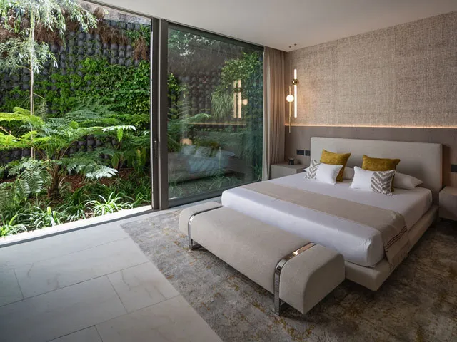 Bedroom exterior with lush planting and wide glass doors at Villa Kaizen, La Zagaleta